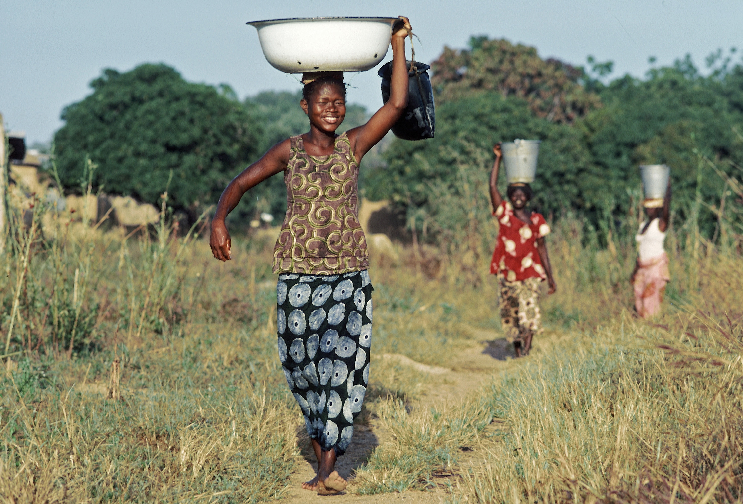 En kvinne bærer vann på et fat på hodet