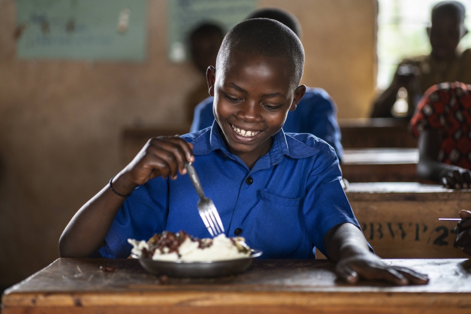 En skoleelev i Rwanda spiser et måltid levert av Verdens matvareprogram på skolen