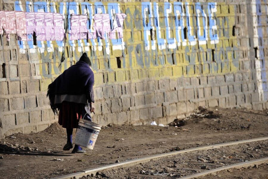En bostedsløs kvinne som går ned veien med en bøtte i hånden i Potosí, Bolivia. Omtrent 39 prosent av bolivianere lever i fattigdom, som er et av de høyeste tallene i Sør-Amerika.
