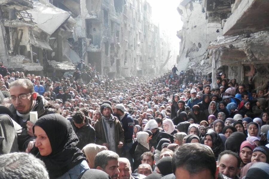 Syyrialaiset pakolaiset jonottavat YK:n toimittamaa ruoka-apua Yarmoukin pakolaisleirillä lähellä Damaskosta (tammikuu 2014).