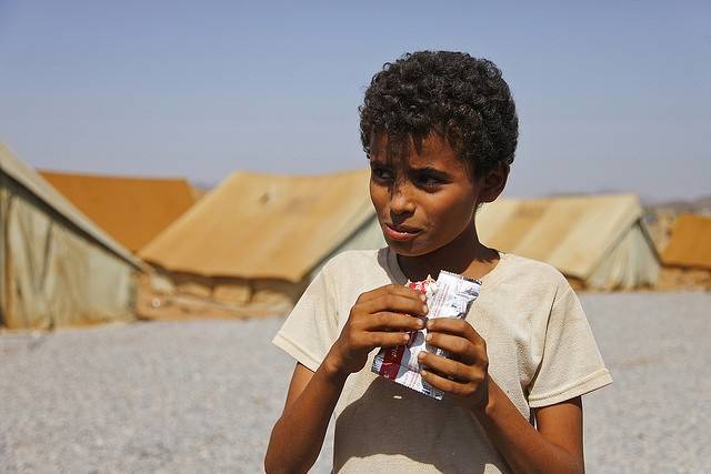 Bilden visar en pojke som äter livsmedelsbistånd i ett läger i Mazrak 2009. Ett läger för internflyktingar i nordvästra Jemen. UNICEF distribuerar mat till barn för att motverka undernäring. Foto: Hugh Macleod / IRIN / Flickr