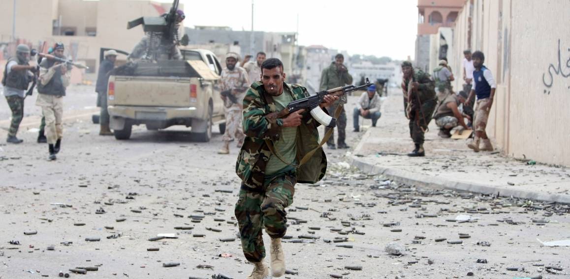 En soldat söker skydd under striden för staden Sirte i slutet av Gaddafis tid vid makten, den 19 oktober 2011. Foto: NTB Scanpix/AFP photo/Ahmad al-Rubaye