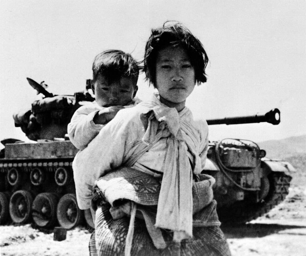 En nio år gammal flicka bär på sin lillebror. Bilden av det föräldralösa syskonparet på flykt togs under Koreakrigen, 9 Juni 1951. Foto: UN Photo/United States Navy.