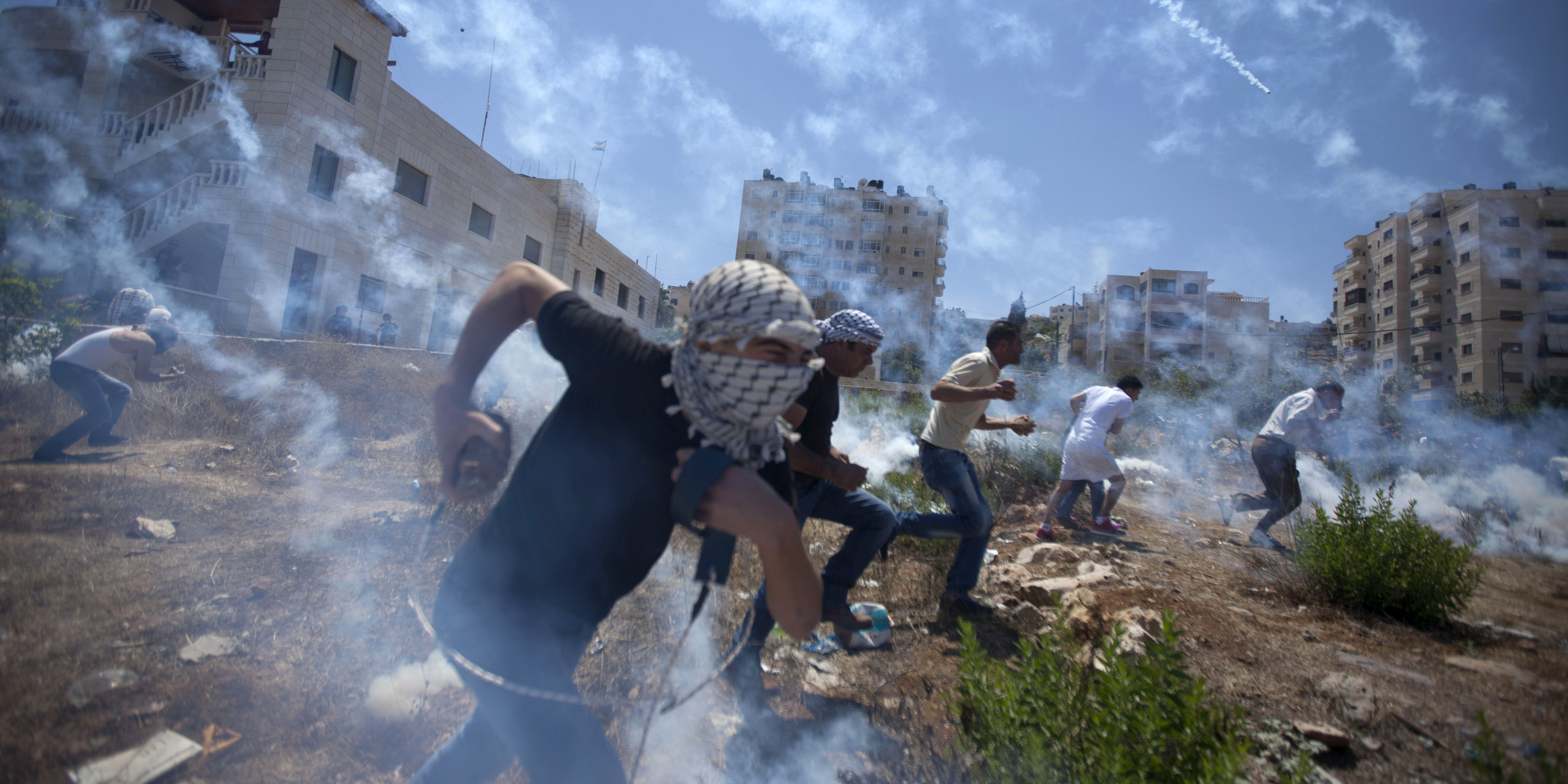Palestinier demonstrerar mot krigen på Gaza, augusti 2014, och möts med tårgas. Foto: AP/Majdi Mohammed