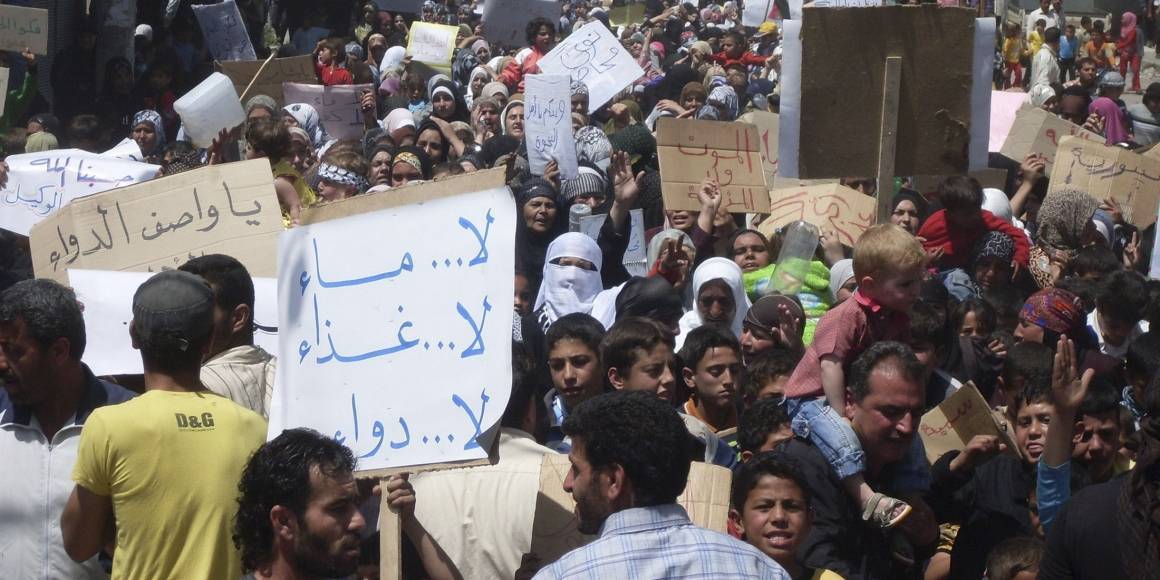 April 2011. Folk samlas i staden Nawa, nära Deraa, i en av de första demonstrationerna mot regimen. Skylten lyder