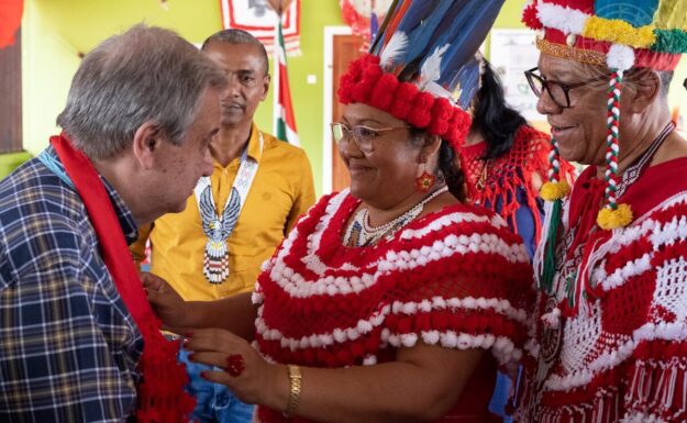 FNs generalsekretær António Guterres (til venstre) møter medlemmer av landbrukskooperativer ledet av urfolk i landsbyen Pierre Kondre-Redi Doti, i Surinams tropiske skogbelte.