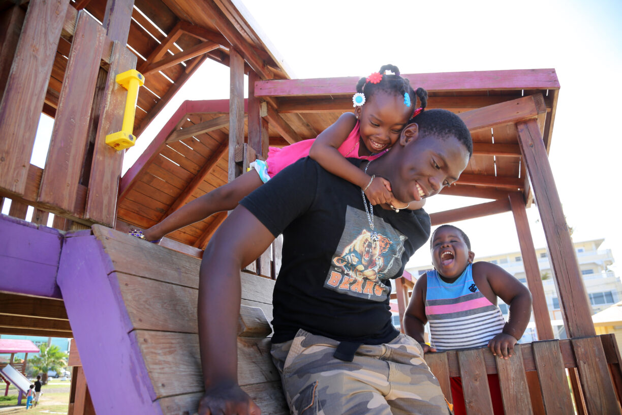 En fersk FN-rapport har funnet at rasisme mot barn av afrikansk avstamning betyr at de ikke blir sett på som barn iac samfunnet. Her leker tre år gamle Alishia Gentle med broren sin – 17 år gamle Andrew – og fetteren hennes, KJ. Foto: UNICEF/UN033875/LeMoyne