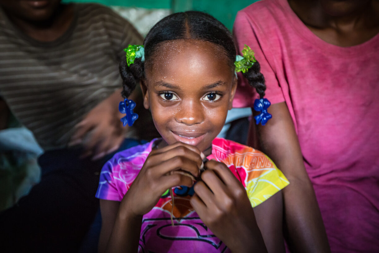 Ett tilfelle av kolera er bekreftet i Haitis hovedstad. En ung pike smiler til kamera på et bakeri i Port-Au-Prince. Foto: UNICEF/Bradley.