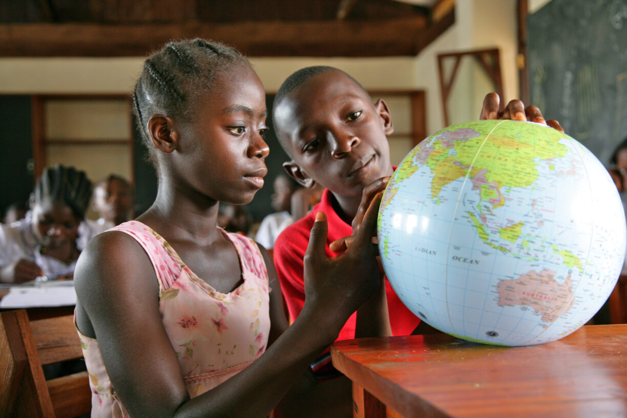 Norges statsbudsjett for 2023 ble lagt frem 6. oktober. Dette viser redusert støtte til livsviktig offisiell utviklingsbistand. Her er barn i Liberia som ser på en verdensklode. Foto: UNICEF/UNI118056/Pirozzi.