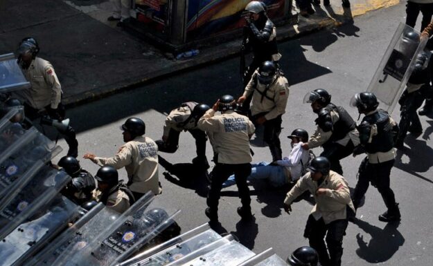 Politiet arresterer en student under en opposisjonsdemonstrasjon mot regjeringen til Venezuelas president Nicolas Maduro, i Caracas.