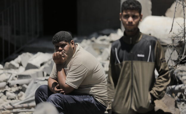 En ung mann sitter på ruinene av sitt ødelagte hjem i Beit Hanoun. Hundrevis av familier på Gazastripen måtte forlate hjemmene sine på grunn av eskalering av angrep.