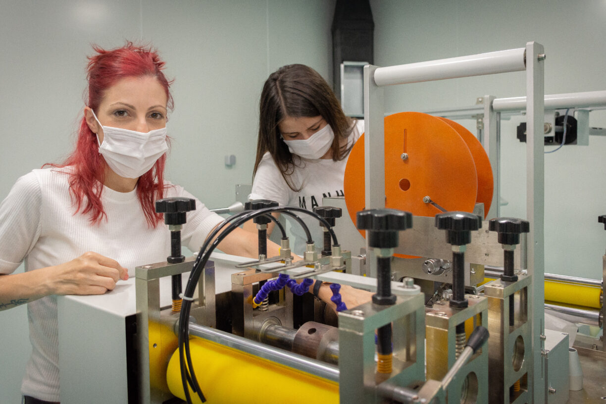 To kvinnelige arbeidere utforsker en ny maskin som lager N-95 kirurgiske munnbind for covid-19-beskyttelse i Tyrkia. Foto: ILO/Kivanc Ozvardar.