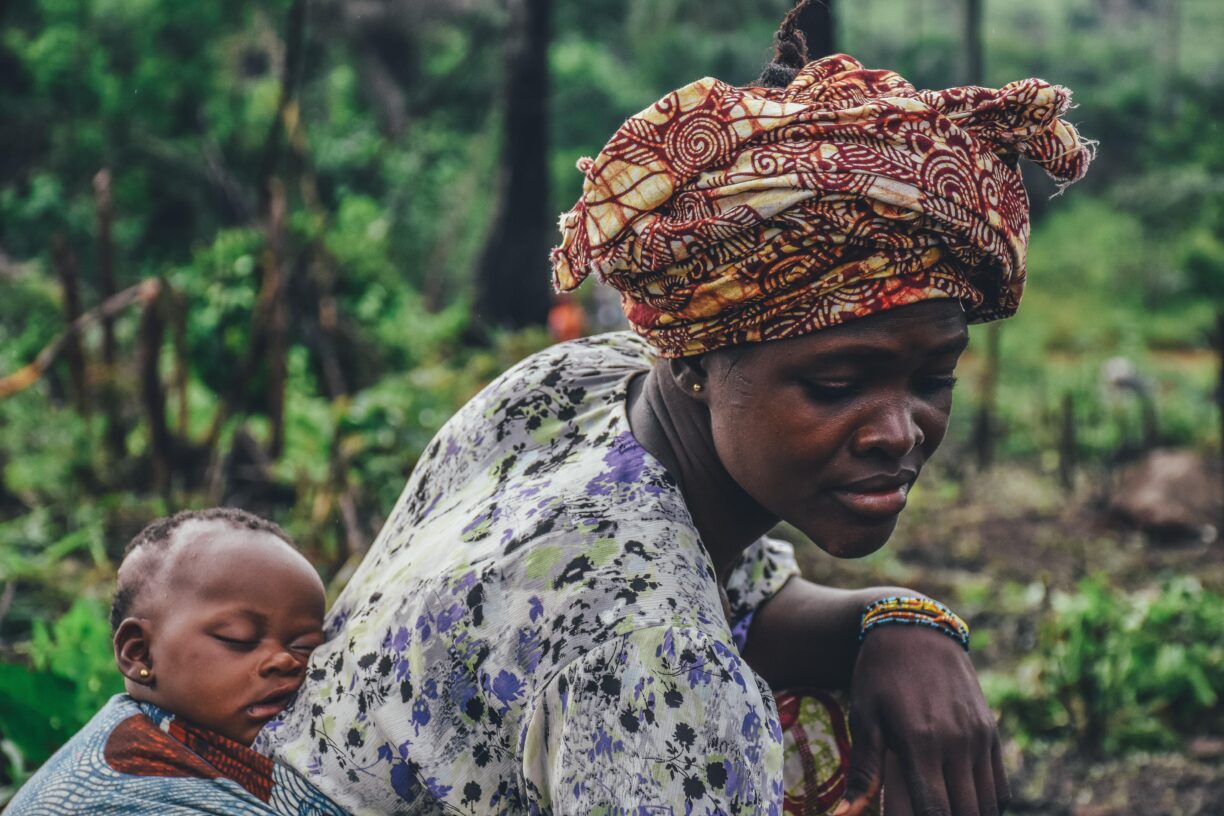 En mor bærer barnet sitt i Sierra Leone. Foto: Annie Spratt/Unsplash