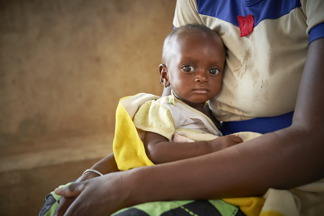 Zourata Sawadogo holder babyen sin, som lider av alvorlig akutt underernæring, på barneavdelingen ved Barsalogho medisinske senter i Burkina Faso. Foto: OCHA/Bénédicte Bienzi Toé.