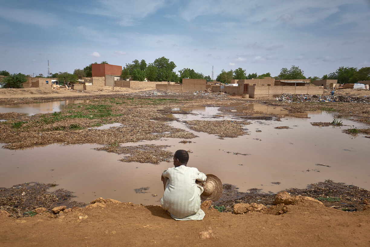 Hama Sorka, en 75 år gammel fisker fra Saguia i Niamey, ser på området der huset hans en gang sto før det ble oversvømmet på grunn av kraftig nedbør i nabolaget hans. Da Hama mistet huset og levebrødet sitt i oktober 2020 på grunn av flommen, fant han tilfluktssted i Gamou-området for internt fordrevne i Niamey. Foto: OCHA/Michele Cattani.