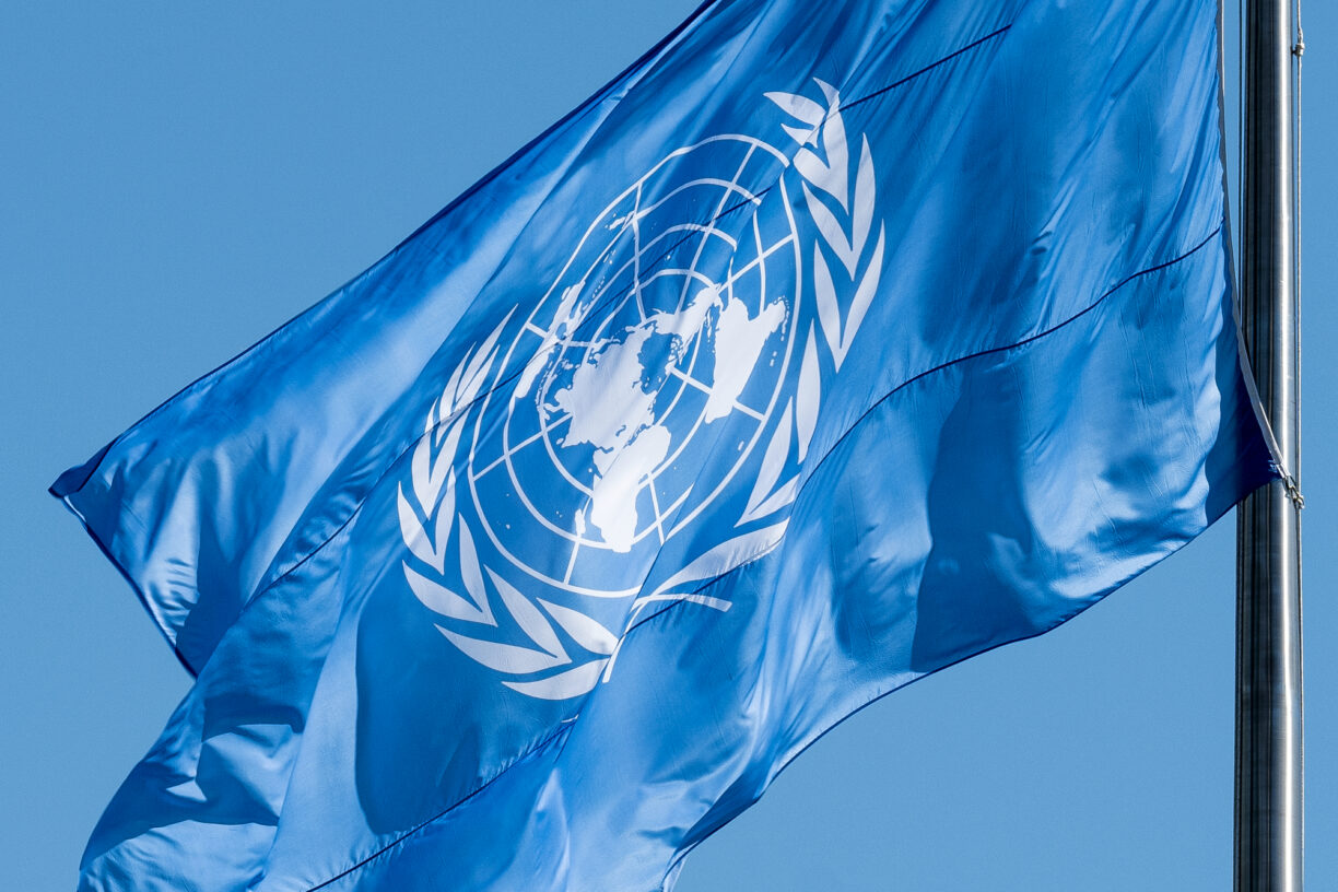 FN-flagget ble offisielt tatt i bruk i 1947. Flagget består av FNs emblem i hvitt mot en blå bakgrunn. Hvitt og blått er FNs offisielle farger. Olivengrenene symboliserer fred, og kartet representerer alle verdens land og folk. Foto: UN Photo/Loey Felipe