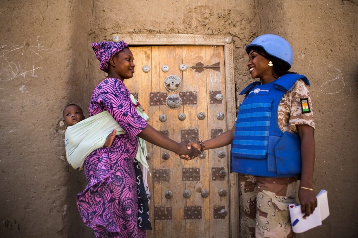 En UNPOL-offiser (FN-politi) hilser på en kvinne og babyen hennes mens de er på patrulje i Timbuktu i Mali i 2017. FN-styrkene trakk seg ut av Mali sommeren 2023. Foto: UN Photo/ Harandane Dicko