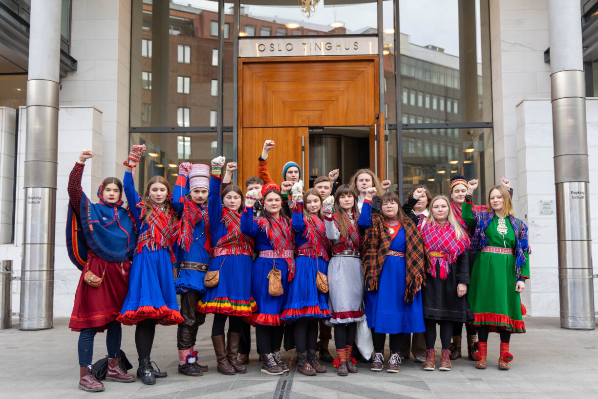 Nå skal Norges respekt for menneskerettighetene granskes i FNs landhøringer – for fjerde gang. Gjennomgangen holdes på mandag 4. november og anbefalingene kommer på fredag 8. november. Her står unge aktivister utenfor Oslo Tinghus i mars 2024. Da var 18 tiltalte i retten for ikke å ha overholdt politiets belegg om å forlate departementene under den store protesten i 2023. Foto: Natur og Ungdom/Lovise Tokle Rannekleiv/Flickr