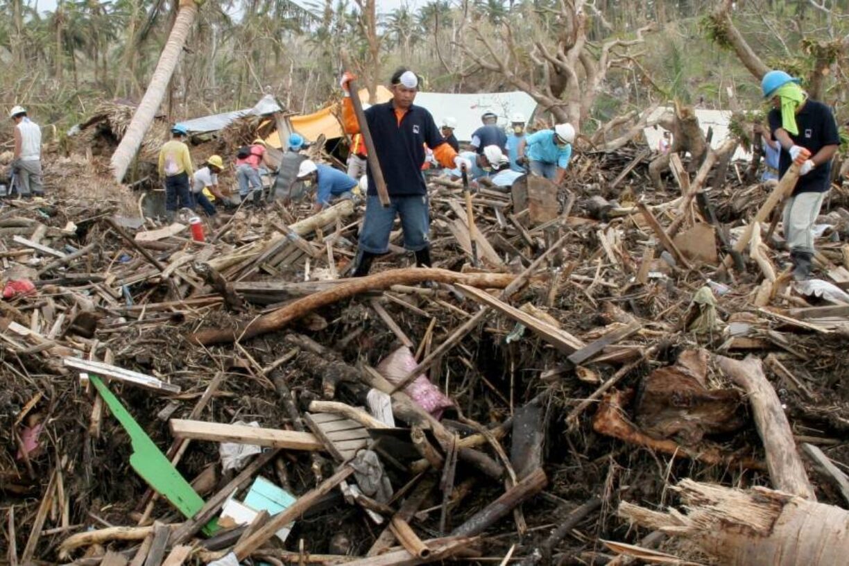 Overlevende og redningsmannskap går gjennom restene av en landsby etter at en storm utløste et jordskred i Bicol, Filippinene i 2007. Foto: Jason Gutierrez/IRIN