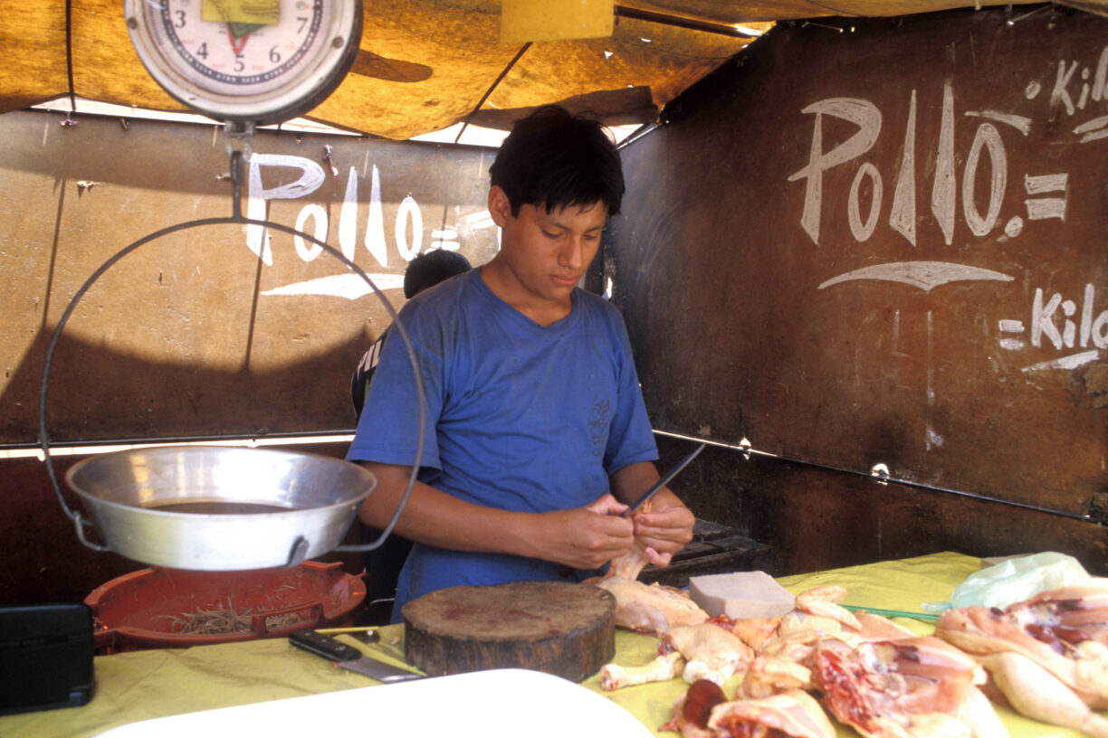 Nedgangstidene merkes over hele Latin-Amerika. Her forbereder en selger mat på et marked i Lima, Peru. Foto: ILO/Lord R.