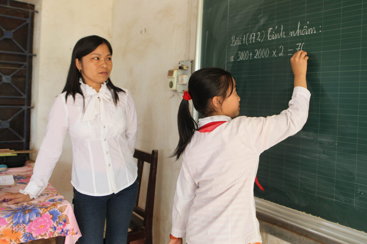 En lærer og eleven hennes løser mattestykker på en skole i Vietnam. Foto: ILO/Truong Van Vi